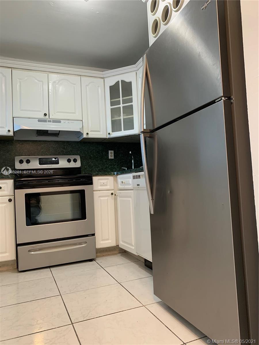 1325 West 68th Street, Unit 514 Hialeah, FL 33014 - Photo 9 of 20 a kitchen with white cabinets and white appliances