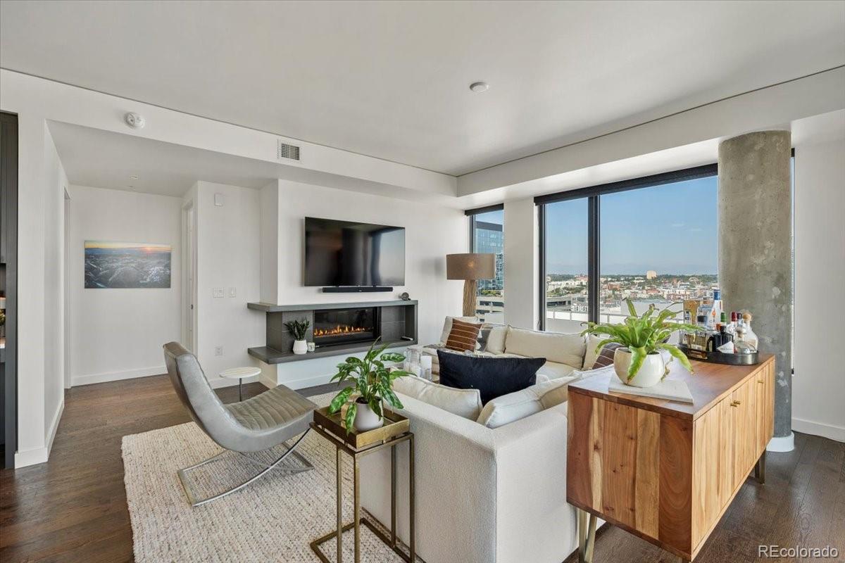 1750 Wewatta Street, Unit 1701 Denver, CO 80202 - Photo 12 of 35 a living room with furniture a flat screen tv and a large window