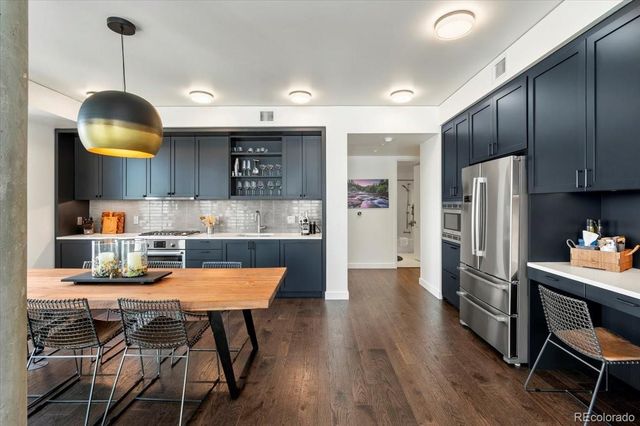 a kitchen with stainless steel appliances granite countertop a sink refrigerator and cabinets