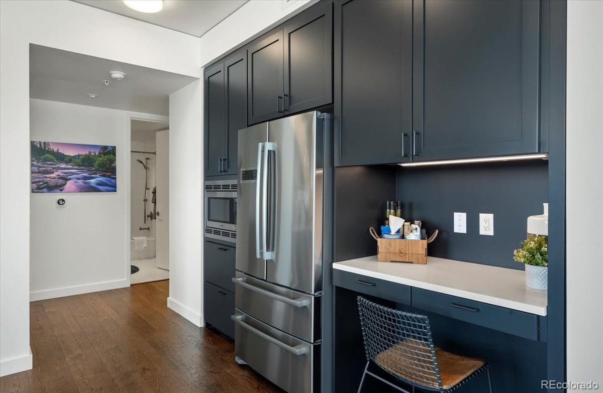 1750 Wewatta Street, Unit 1701 Denver, CO 80202 - Photo 9 of 35 a kitchen with stainless steel appliances a refrigerator and wooden floor