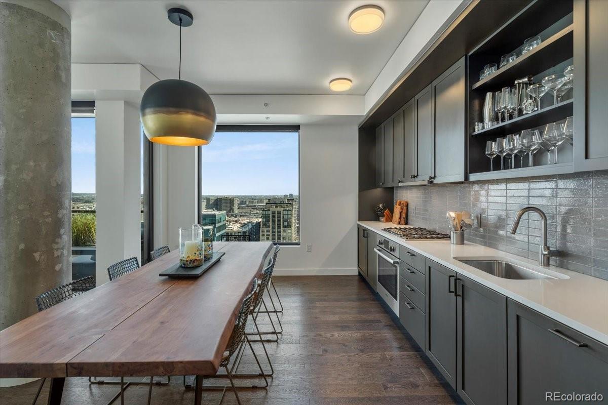 1750 Wewatta Street, Unit 1701 Denver, CO 80202 - Photo 10 of 35 a kitchen with a table chairs sink and cabinets
