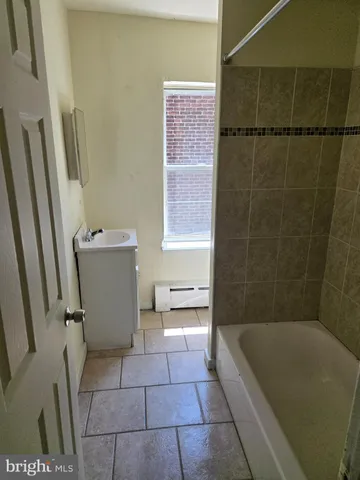 a bathroom with a tub a sink a toilet and a shower