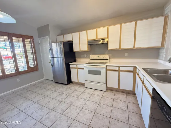 a kitchen with a stove a sink dishwasher and a refrigerator