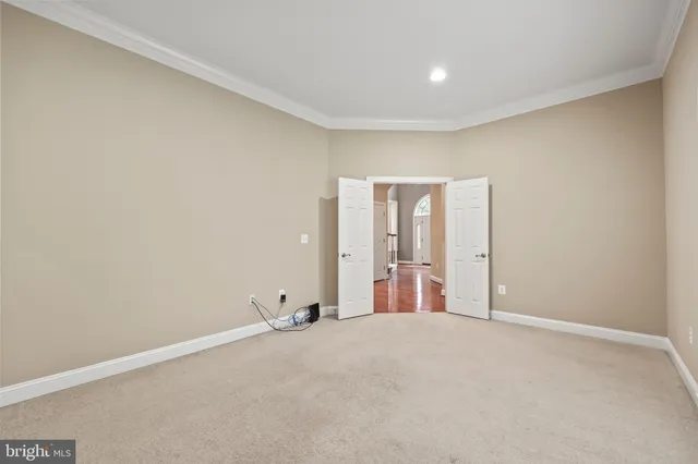 an empty room with chandelier fan and windows