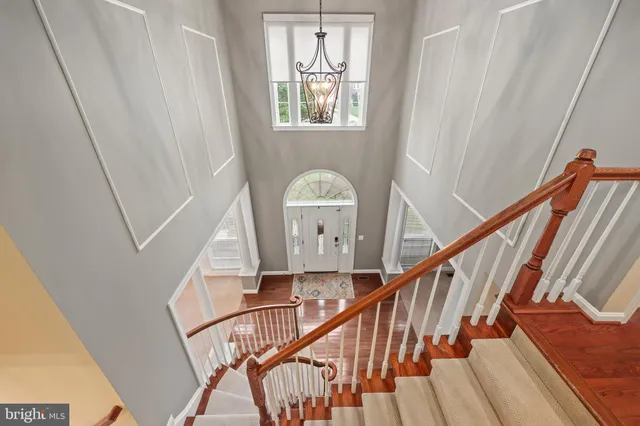 a view of an empty room with chandelier fan and a fireplace