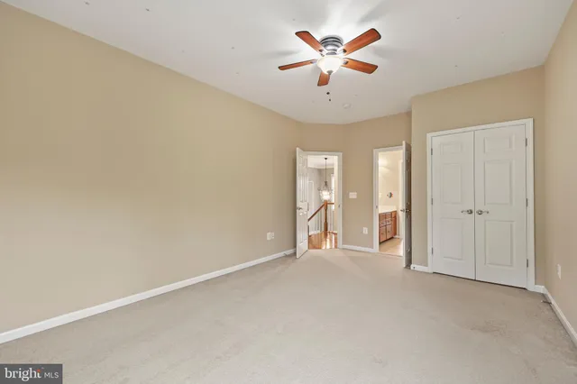 an empty room with a ceiling fan and a shower