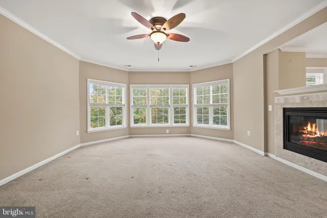 an empty room with wooden floor and natural light