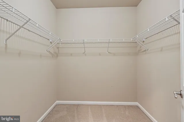 a view of an empty room with a closet and a window