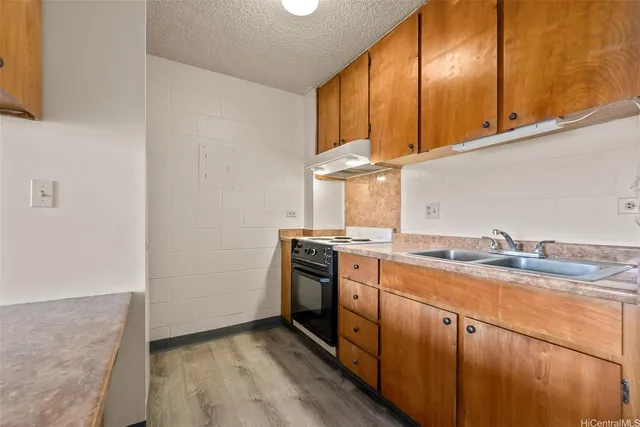 a kitchen with granite countertop stainless steel appliances a sink window and cabinets