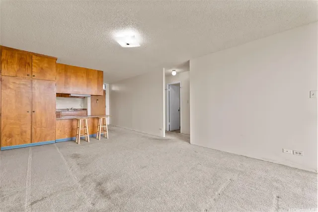 a view of an empty room with kitchen