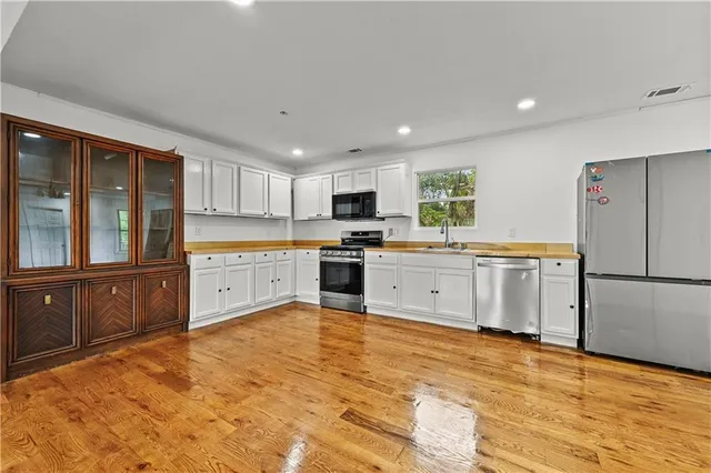 a large kitchen with cabinets and stainless steel appliances