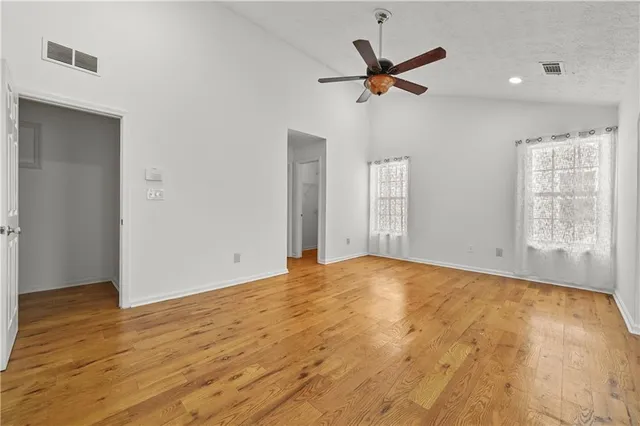 a view of a livingroom with a ceiling fan and wooden floor