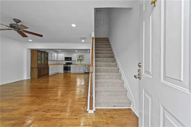 a view of a livingroom with wooden floor and staircase