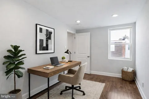 a view of a workspace with furniture and wooden floor