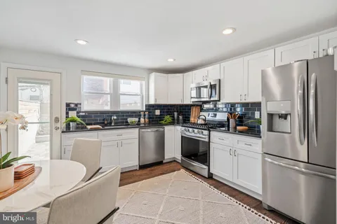 a kitchen with stainless steel appliances granite countertop a refrigerator sink and stove