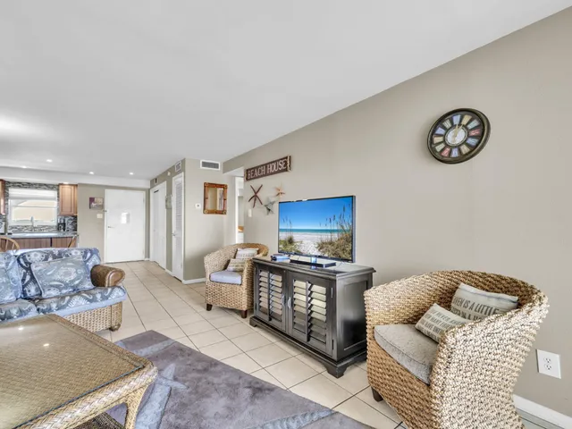 a living room with furniture a flat screen tv and a wall painting