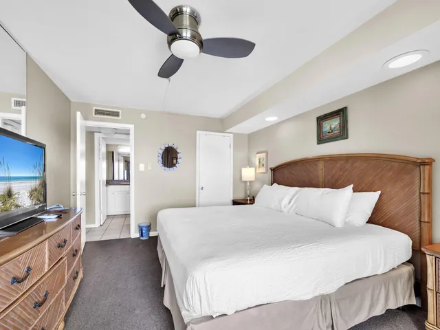 a bedroom with a large bed and a chandelier