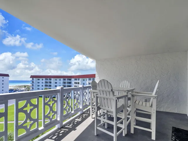 a view of a chairs and table in the balcony