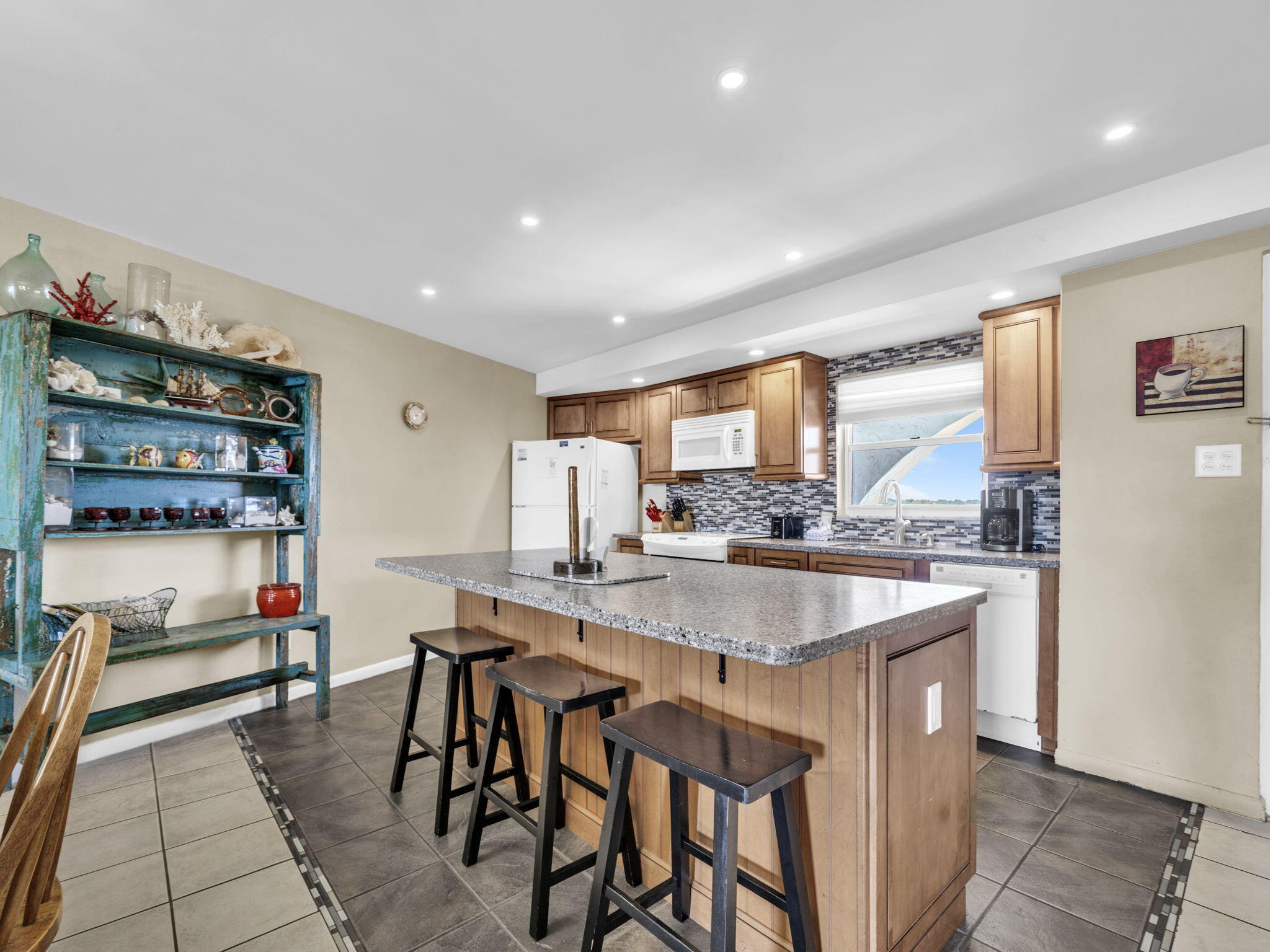 909 Santa Rosa Boulevard, Unit 165 Fort Walton Beach, FL 32548 - Photo 7 of 25 a kitchen with stainless steel appliances granite countertop a table chairs sink and cabinets