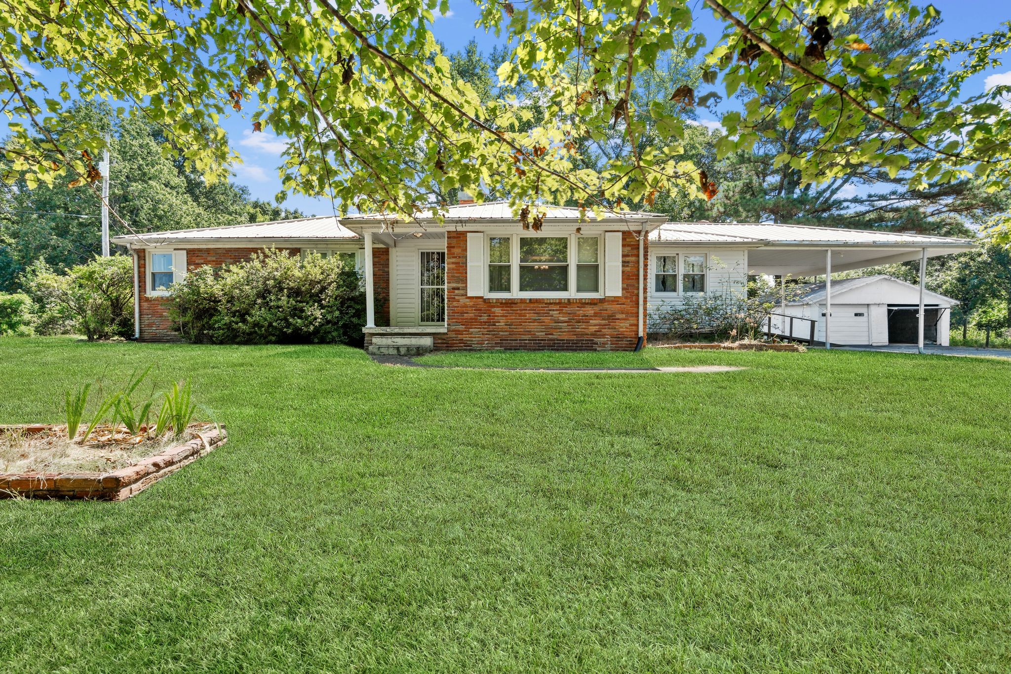 a front view of a house with a garden and yard