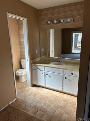 a spacious bathroom with a toilet sink and mirror