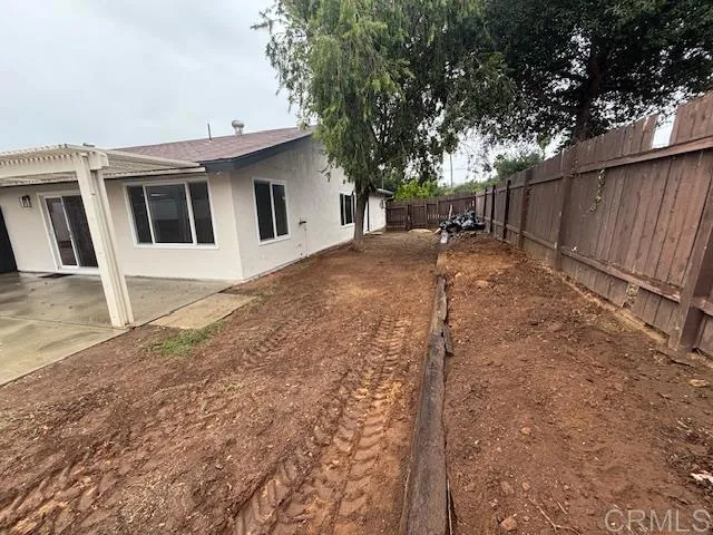 a backyard of a house with table and chairs