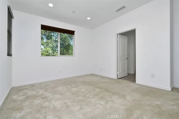 an empty room with white cabinet and mirrors