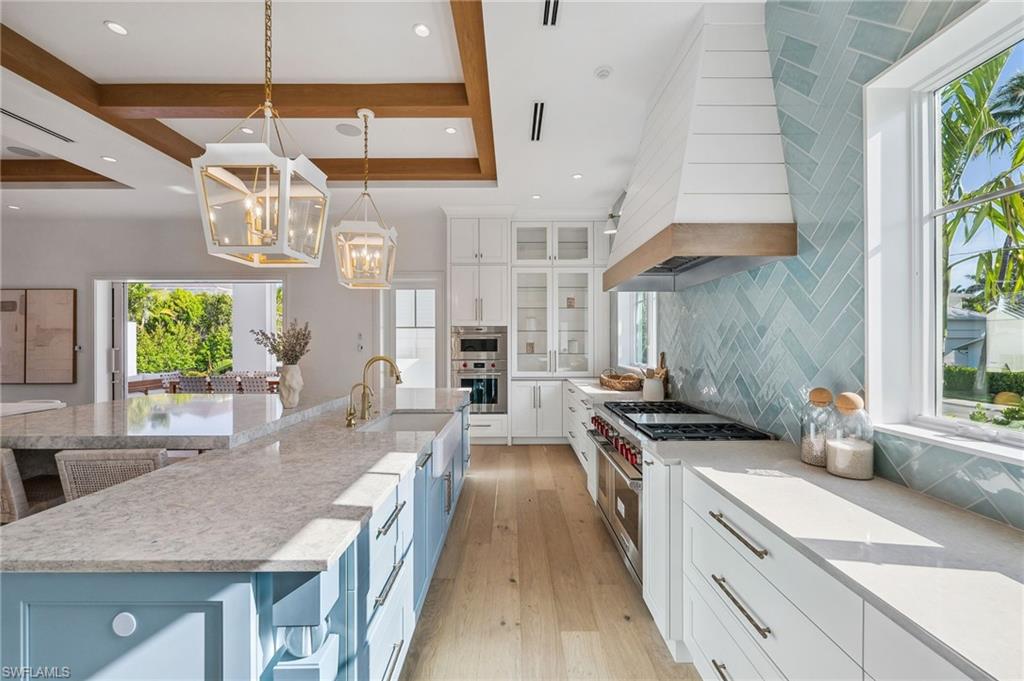187 10th Avenue South Naples, FL 34102 - Photo 15 of 48 a kitchen with stainless steel appliances granite countertop a sink a stove and a wooden floors