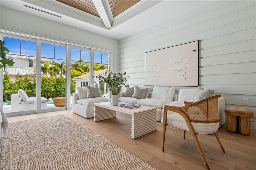 187 10th Avenue South Naples, FL 34102 - Photo 23 of 48 a living room with furniture a lamp and a potted plant