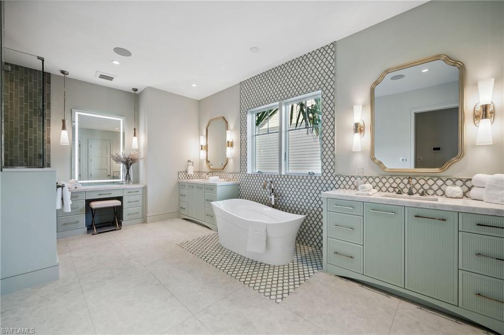 187 10th Avenue South Naples, FL 34102 - Photo 24 of 48 a spacious bathroom with a double vanity sink a mirror and a bathtub
