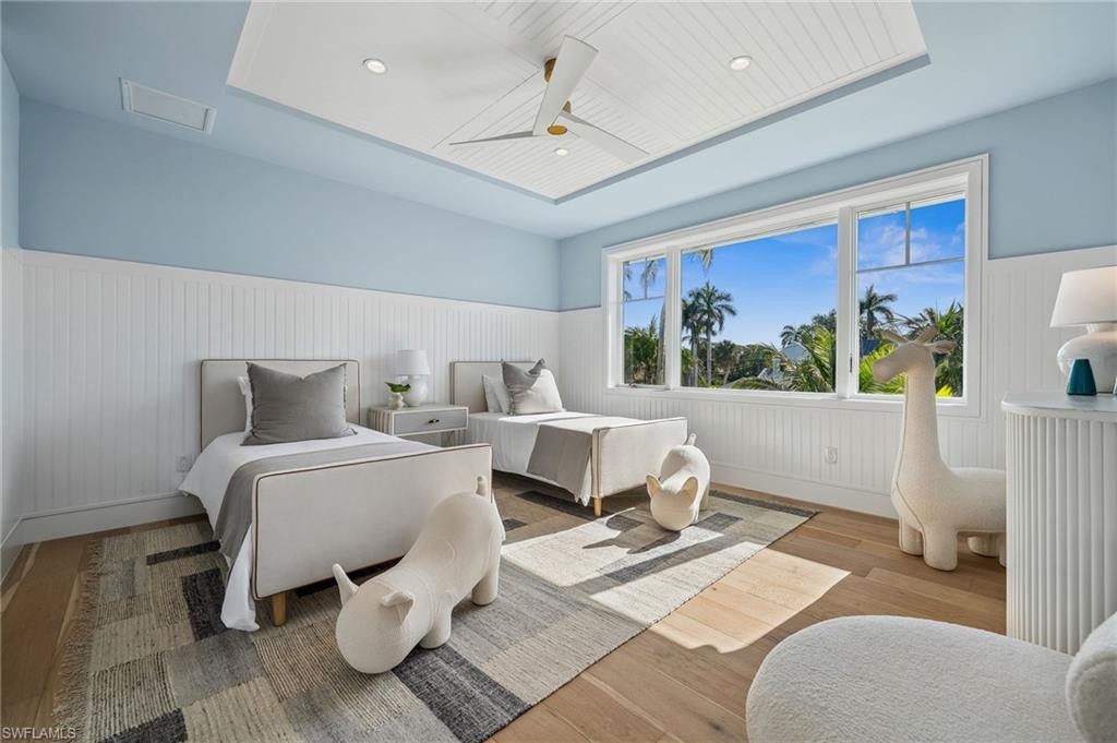 187 10th Avenue South Naples, FL 34102 - Photo 39 of 48 a spacious bedroom with a bed a couch and a large window