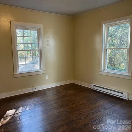 a view of a room with wooden floor and windows