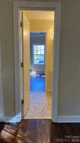 a view of empty room with wooden floor