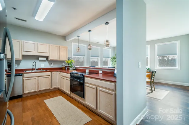 a kitchen with a refrigerator a sink and white cabinets