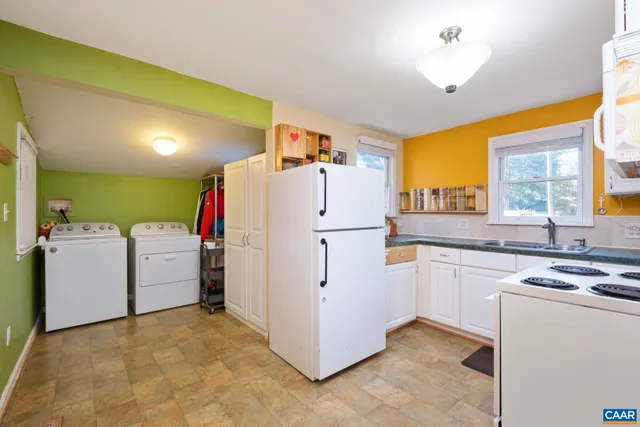 a kitchen with white cabinets and white appliances