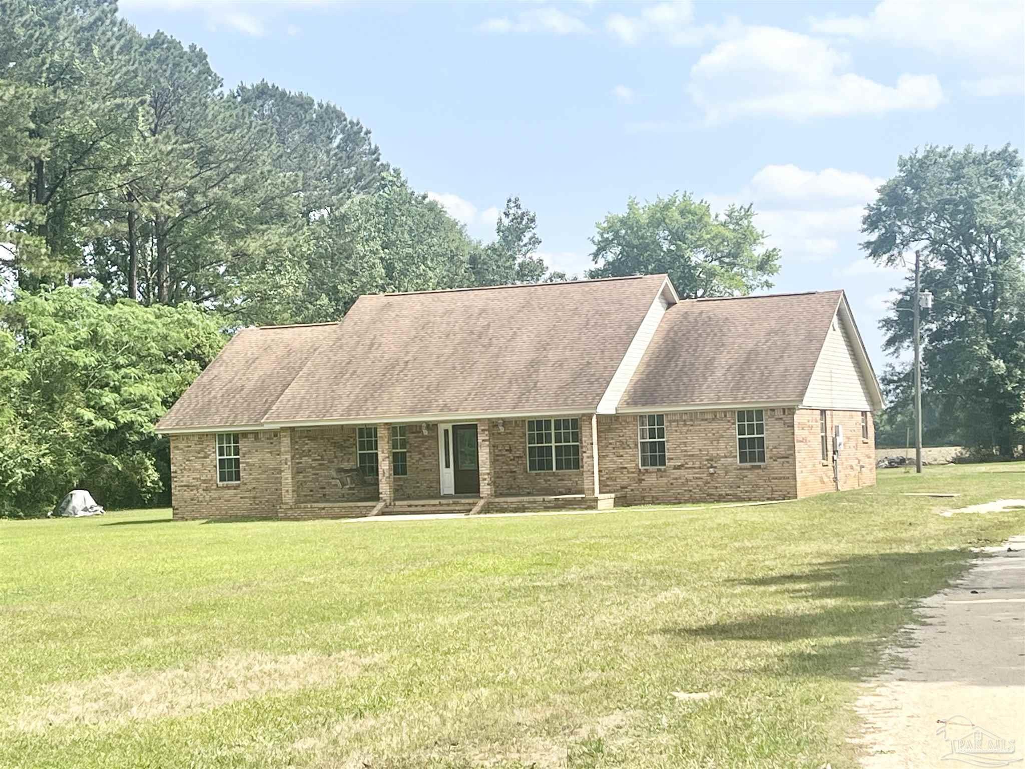 61205 Milstead Road Atmore, AL 36502 - Photo 1 of 26 a front view of a house with a garden and lake view