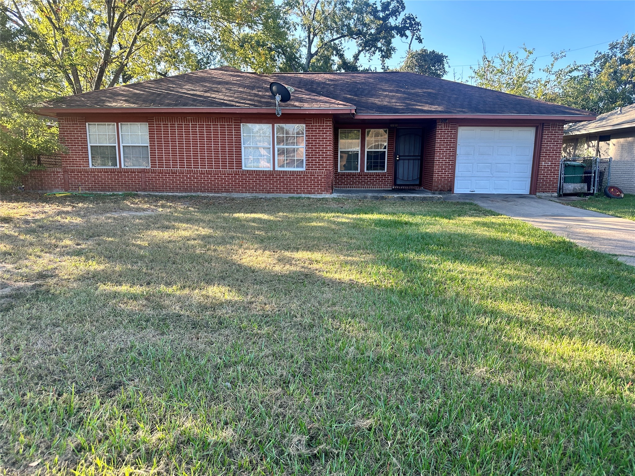 9314 Woodlyn Road Houston, TX 77078 - Photo 4 of 7 a brick house next to a yard with a large tree