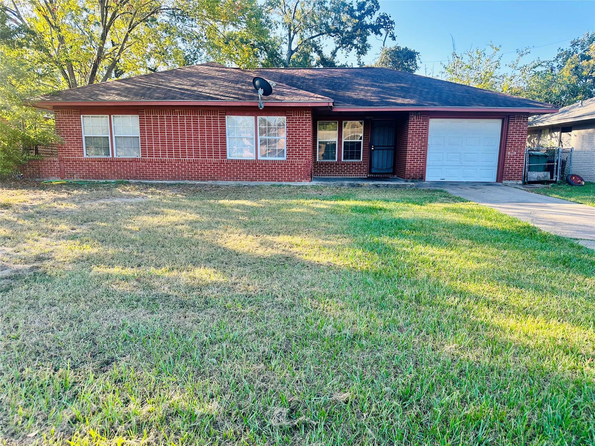 9314 Woodlyn Road Houston, TX 77078 - Photo 5 of 7 a brick house that has a small yard and large trees