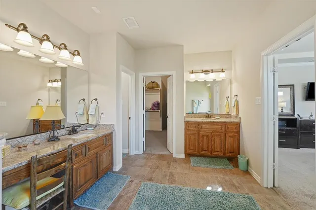 a spacious bathroom with a granite countertop sink a mirror and a shower