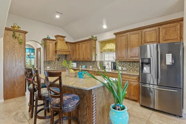 a kitchen with stainless steel appliances granite countertop a refrigerator and a stove top oven