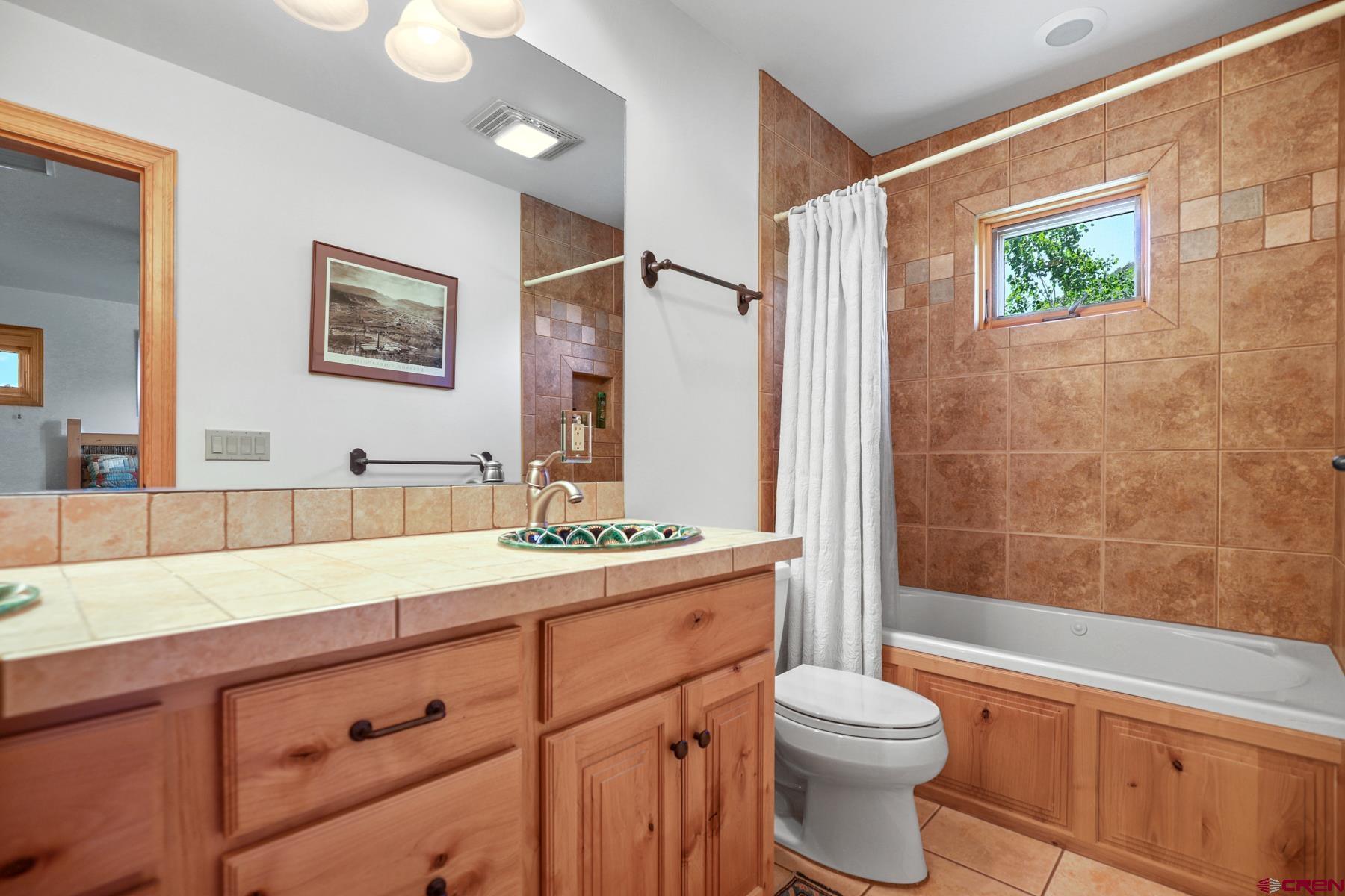 756 Horse Gulch Loop Durango, CO 81301 - Photo 16 of 35 a bathroom with a double vanity sink toilet and shower