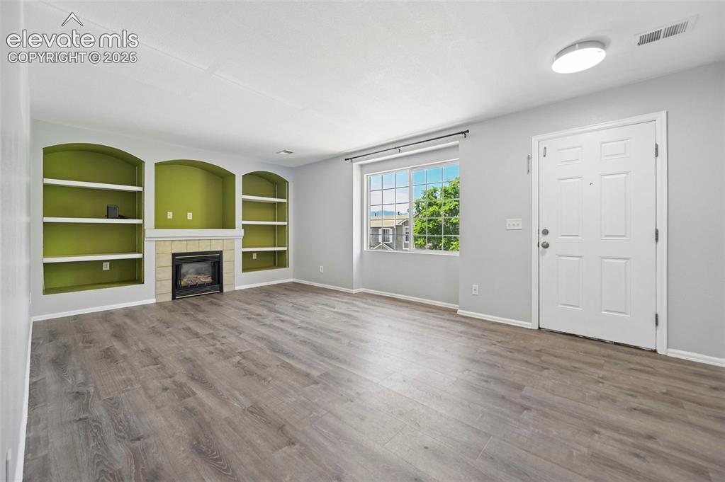 431 Kitfield View Colorado Springs, CO 80916 - Photo 9 of 27 an empty room with a fireplace and window