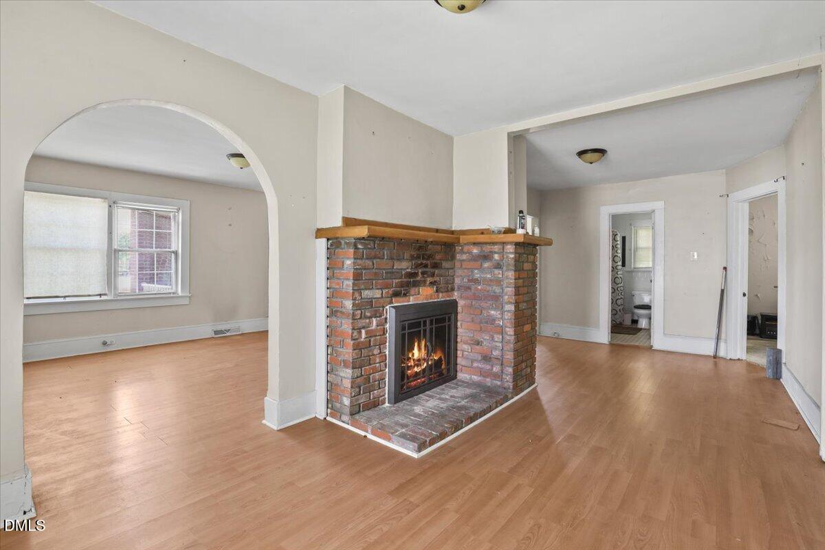 2213 Hunter Hill Road Rocky Mount, NC 27804 - Photo 5 of 11 a view of an empty room with wooden floor fireplace and a window