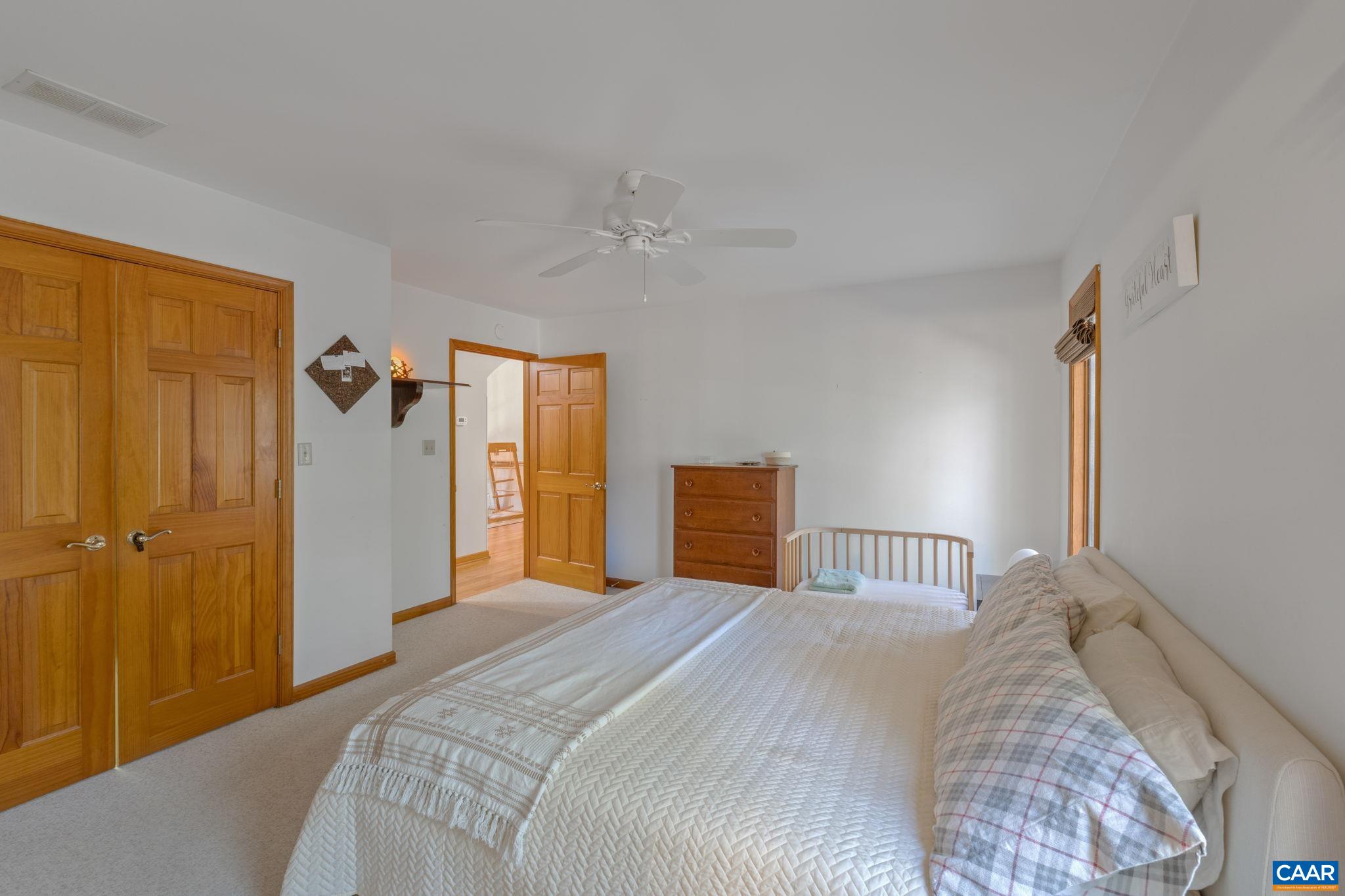 30 Brougham Road Palmyra, VA 22963 - Photo 23 of 57 a bedroom with a large bed and a chandelier