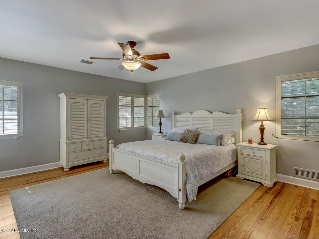 945 Mapleton Terrace Jacksonville, FL 32207 - Photo 13 of 45 a spacious bedroom with a bed and a chandelier