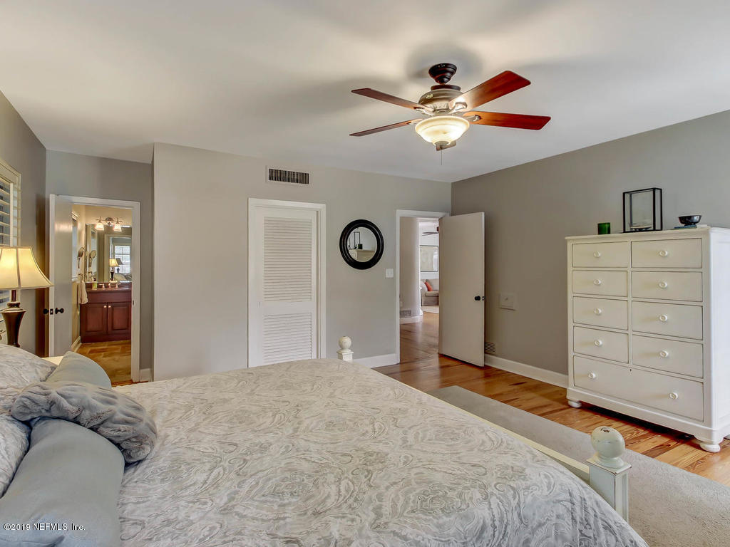 945 Mapleton Terrace Jacksonville, FL 32207 - Photo 14 of 45 a bedroom with a bed and a chandelier