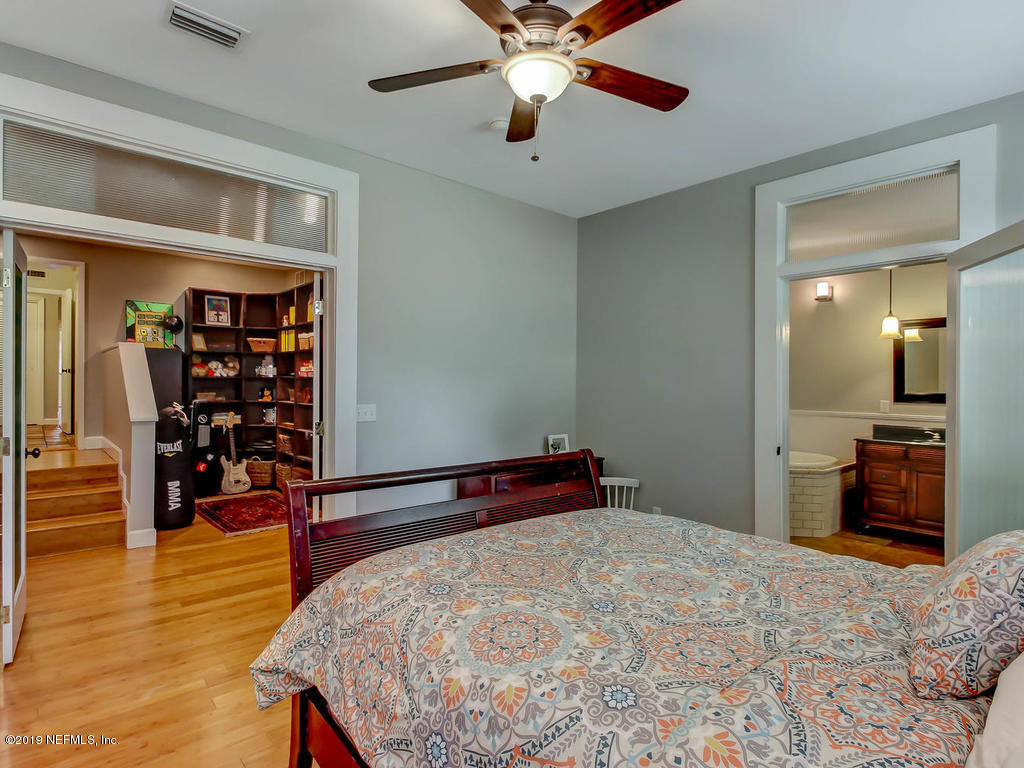945 Mapleton Terrace Jacksonville, FL 32207 - Photo 18 of 45 a bedroom with a bed and a chandelier