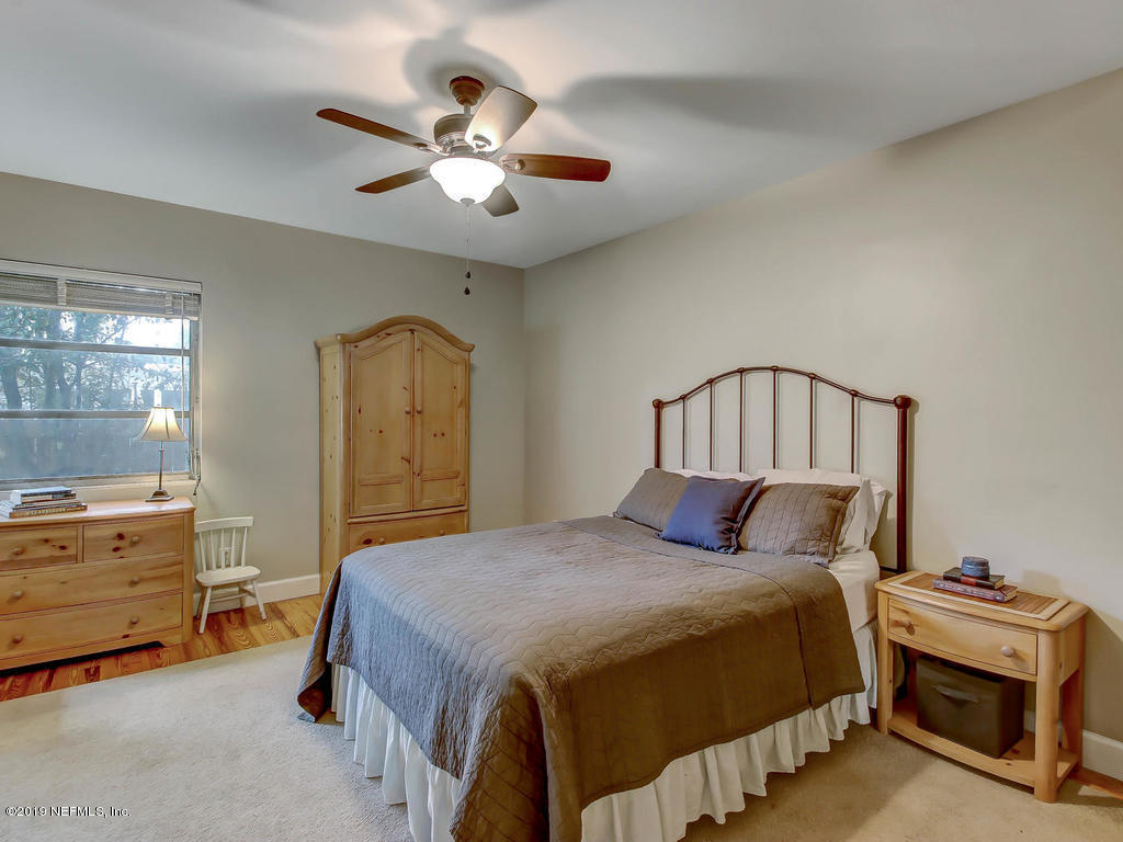 945 Mapleton Terrace Jacksonville, FL 32207 - Photo 22 of 45 a bedroom with a bed and a chandelier