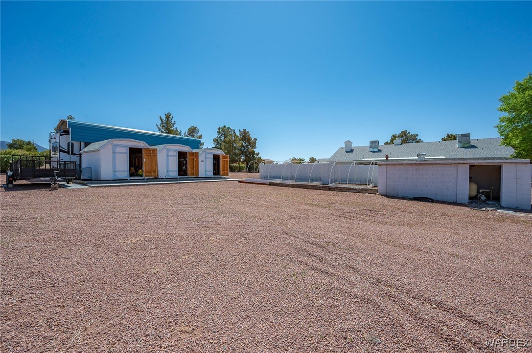 3516 Packsaddle Road Kingman, AZ 86401 - Photo 87 of 100 View of yard featuring 3 storage sheds and garden beds