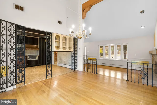 a view of a living room filled with furniture and a chandelier